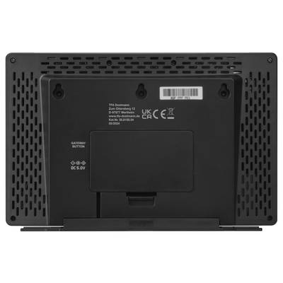 Pogled od zadaj elektronske naprave z prezračevalnimi režami, QR kodo, oznakami za vhodno moč in gumbom za prehod.