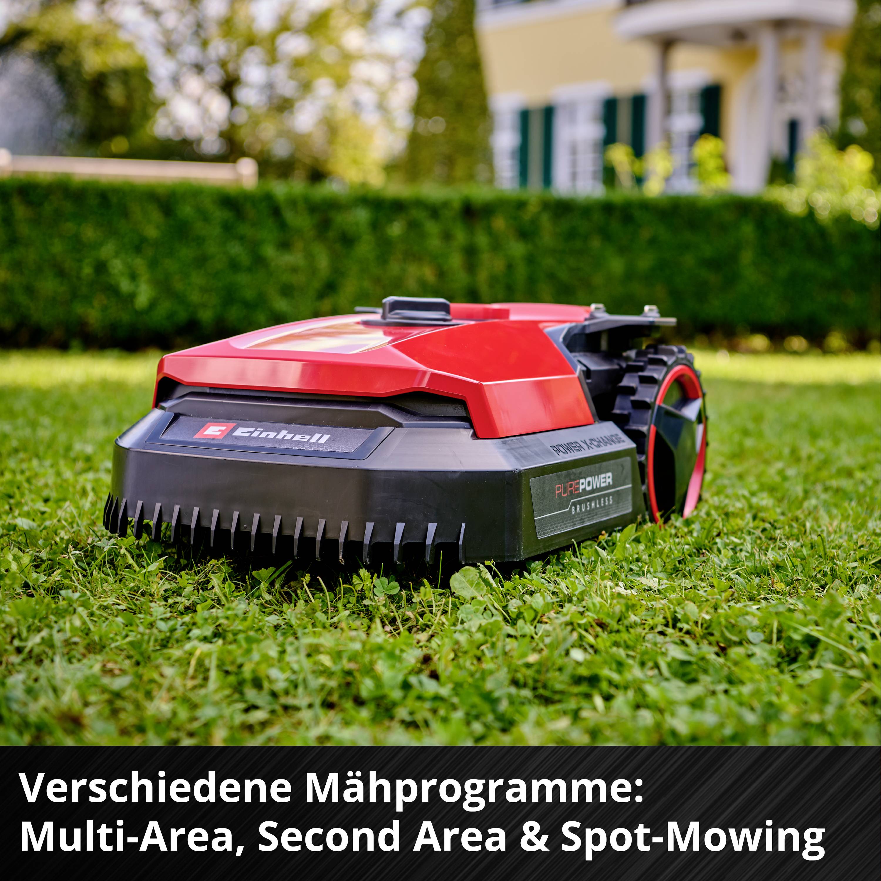 Rdeč robotski kosilnik na zeleni travi pred hišo. Besedilo: 'Različni programi košnje: Multi-Area, Second Area in Spot-Mowing'.