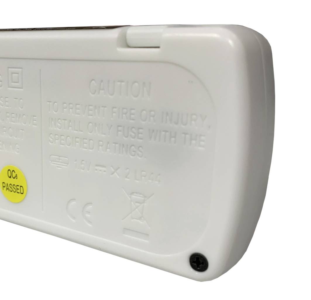 Bela plastična ohišje z nalepko, ki prikazuje 'QC PASSED'. Vsebuje opozorila za varno uporabo baterij.