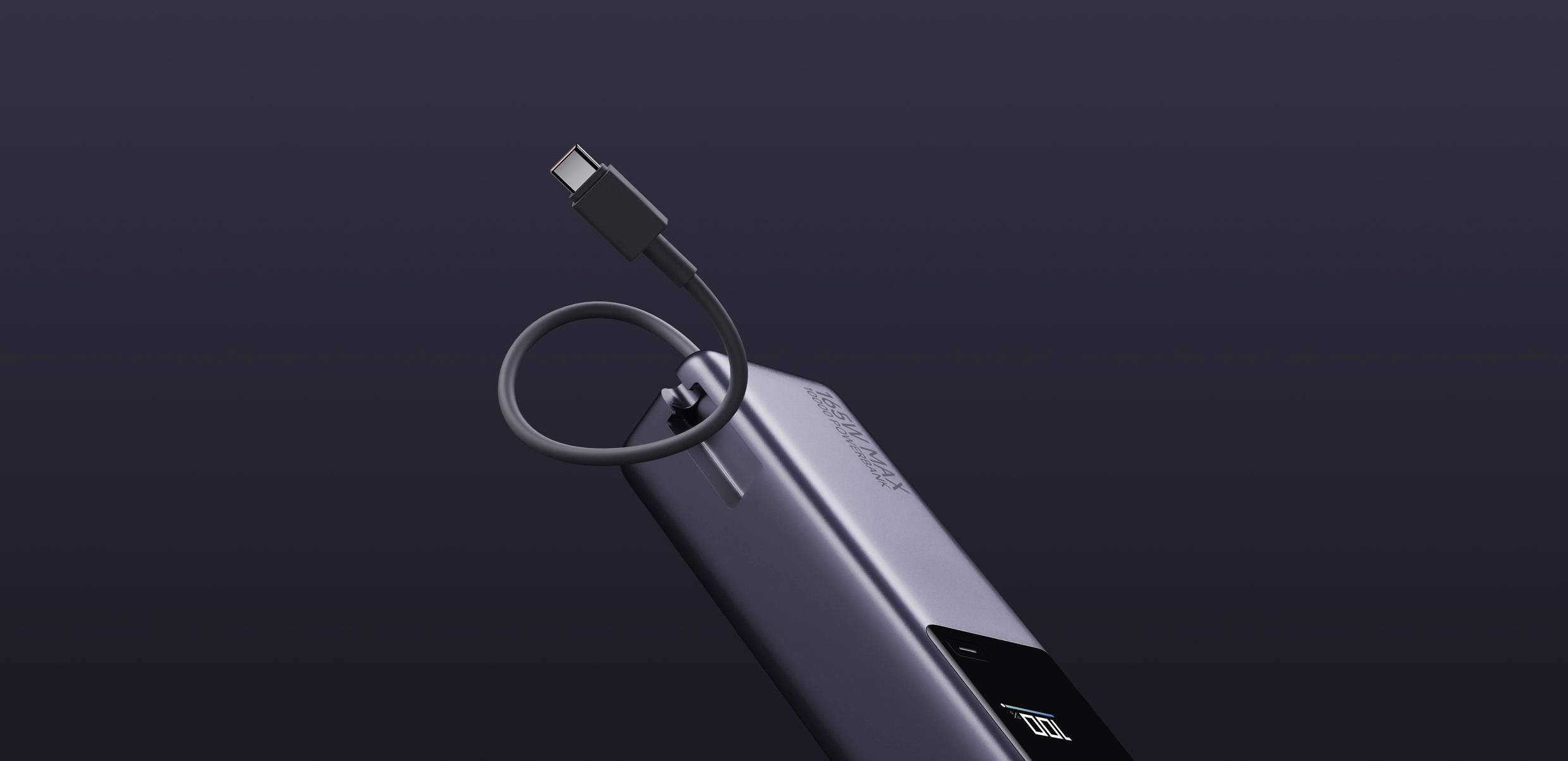 Srebrna mobilna baterija z priključenim USB-C kablom na temnem ozadju.