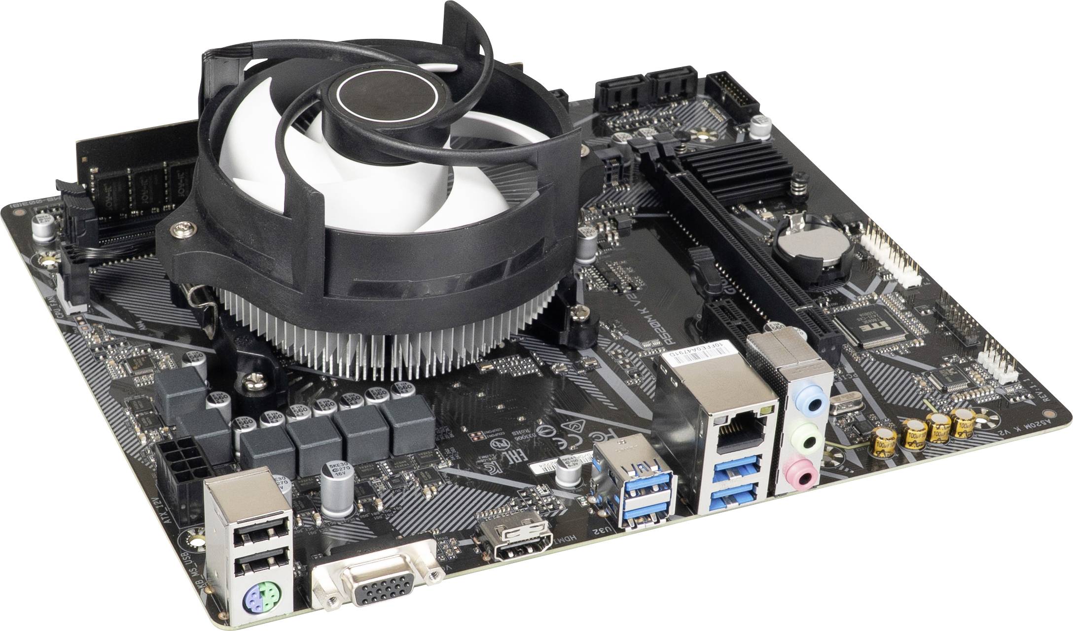 Matična plošča računalnika z ventilatorjem in različnimi priključki, med katerimi so USB, HDMI in Ethernet, položena na mizo.