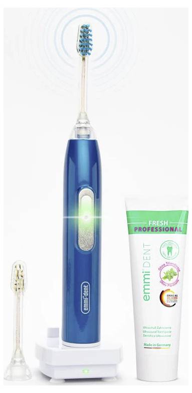 Modra električna zobna ščetka z nadomestno glavo ščetke, polnilno postajo in zobno pasto. Oznaka 'emmi-dent' in napis 'Narejeno v Nemčiji'.