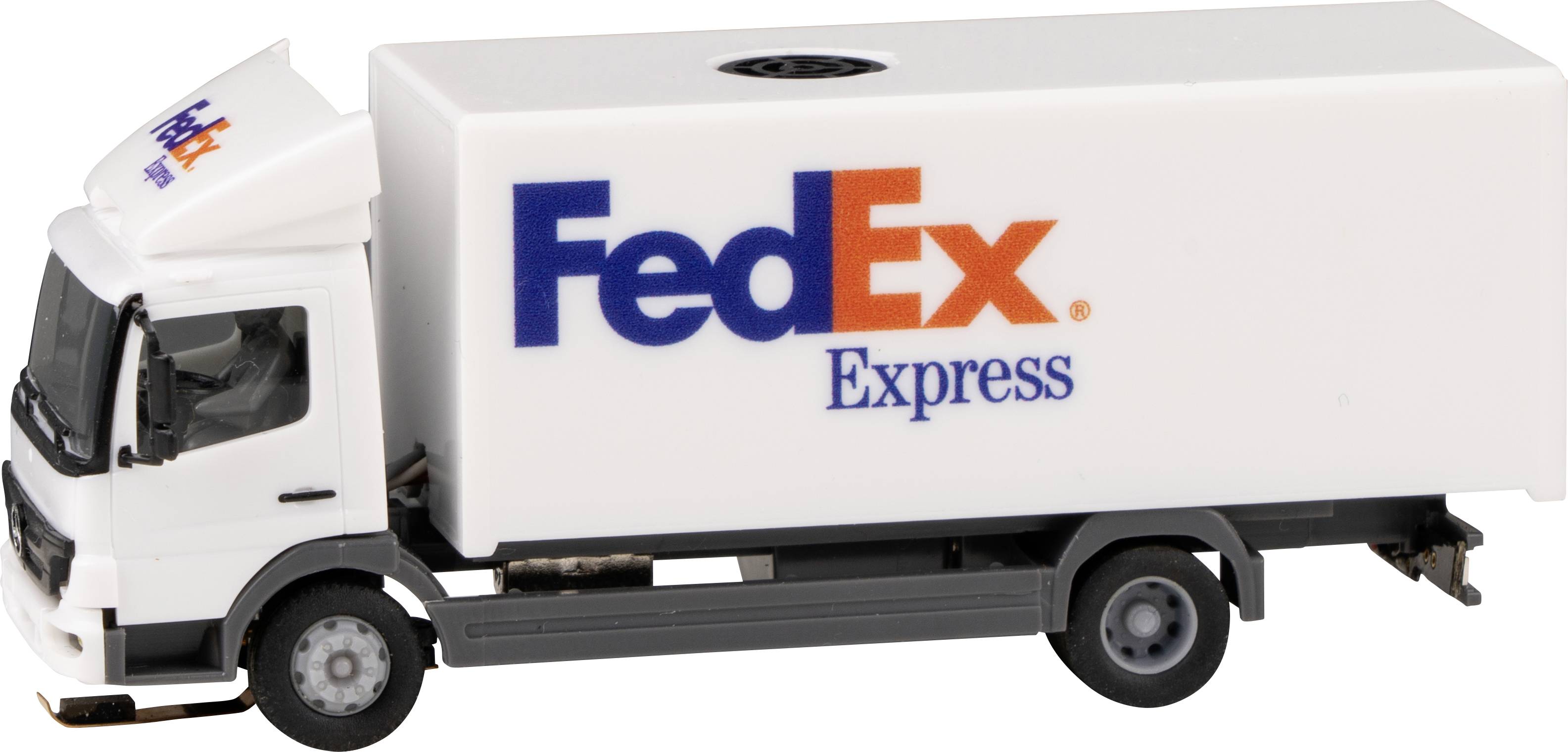 Majhen FedEx dostavni kombi iz plastike v beli barvi z modrimi in oranžnimi logotipi podjetja na strani in kabini.