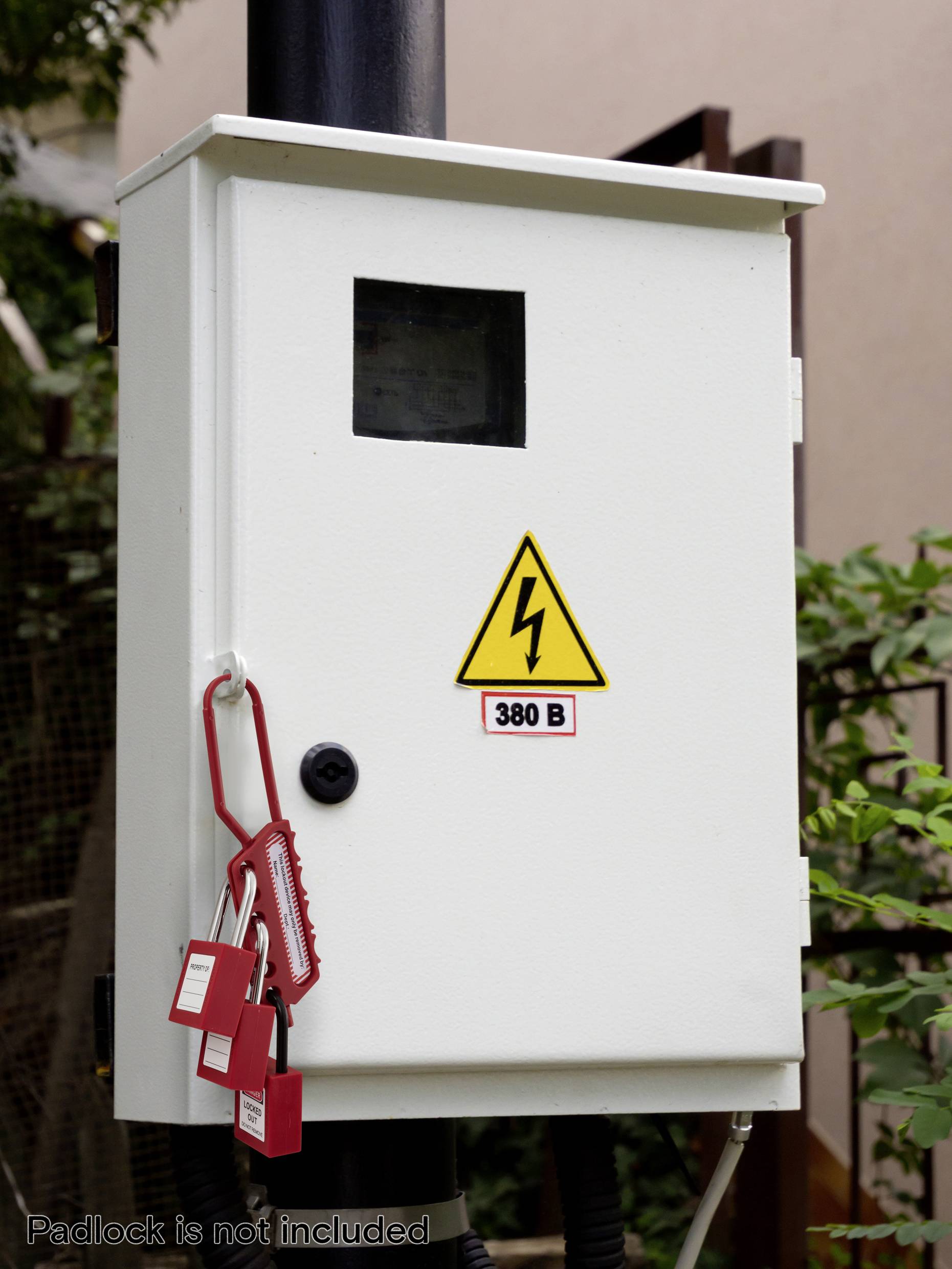 Električna kontrolna omarica na drogu z opozorilnim znakom '380 V' in več oznakami za blokado.