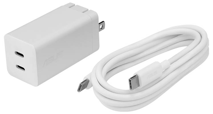 Bela stenska polnilna postaja USB-C z dvema priključkoma in zložljivimi vtičnimi elementi leži na prazni površini skupaj s pripadajočim USB-C kablom.