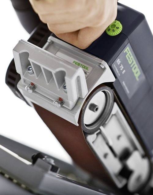 Roka upravlja z Festool BS 75 trakom za brušenje, osredotočena na nastavitvene kontrole in brusilni trak, ki prikazuje prilagajanje orodja med delovanjem.