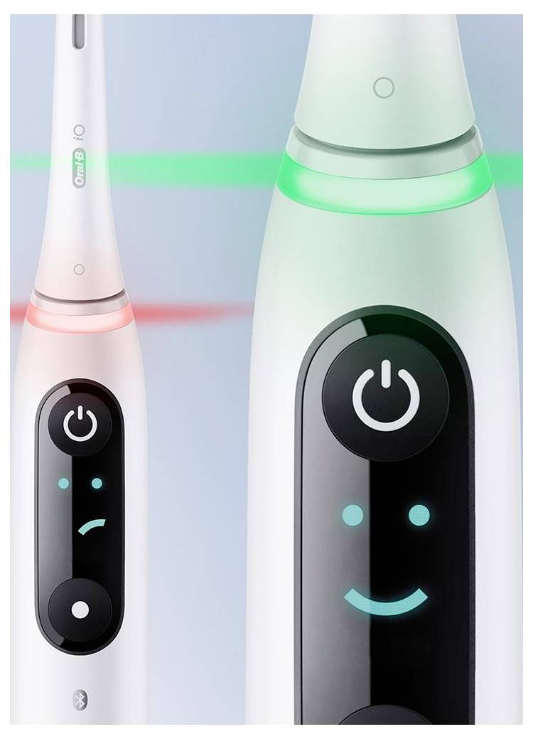 Dva električna zobna ščetka z digitalnimi zasloni; ena prikazuje žalostni obraz z rdečo lučjo, druga pa veseli obraz z zeleno lučjo, kar kaže povratne informacije o ščetkanju.