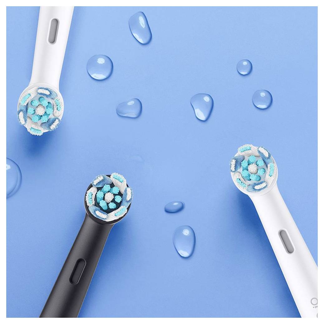 Električne zobne ščetke v črni in beli barvi na modrem ozadju z vodnimi kapljicami, ki prikazujejo teksturo in obliko ščetin.