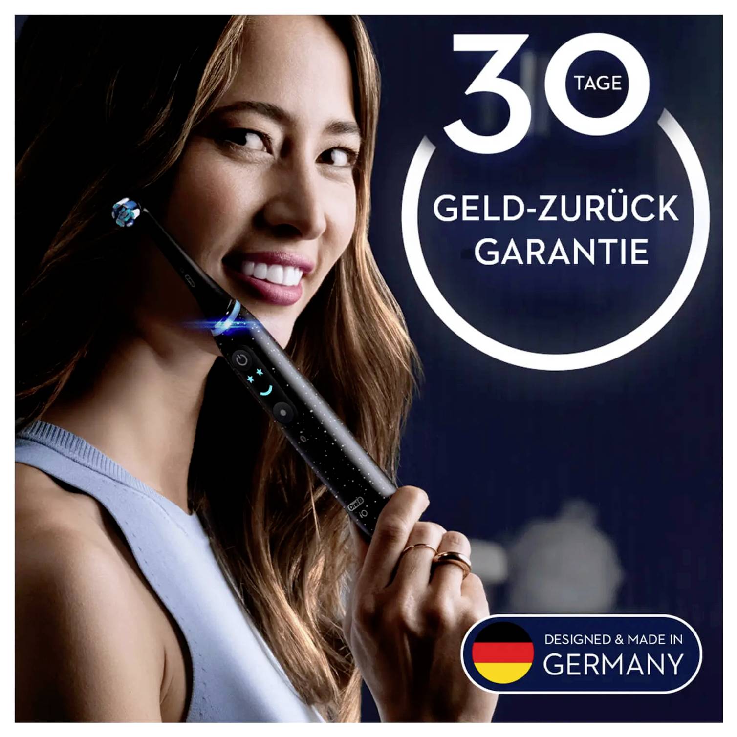 Ženska drži električno zobno ščetko in se smeje. Slika vsebuje besedilo: '30-dnevna garancija vračila denarja' in oznako 'Zasnovano in izdelano v Nemčiji'.