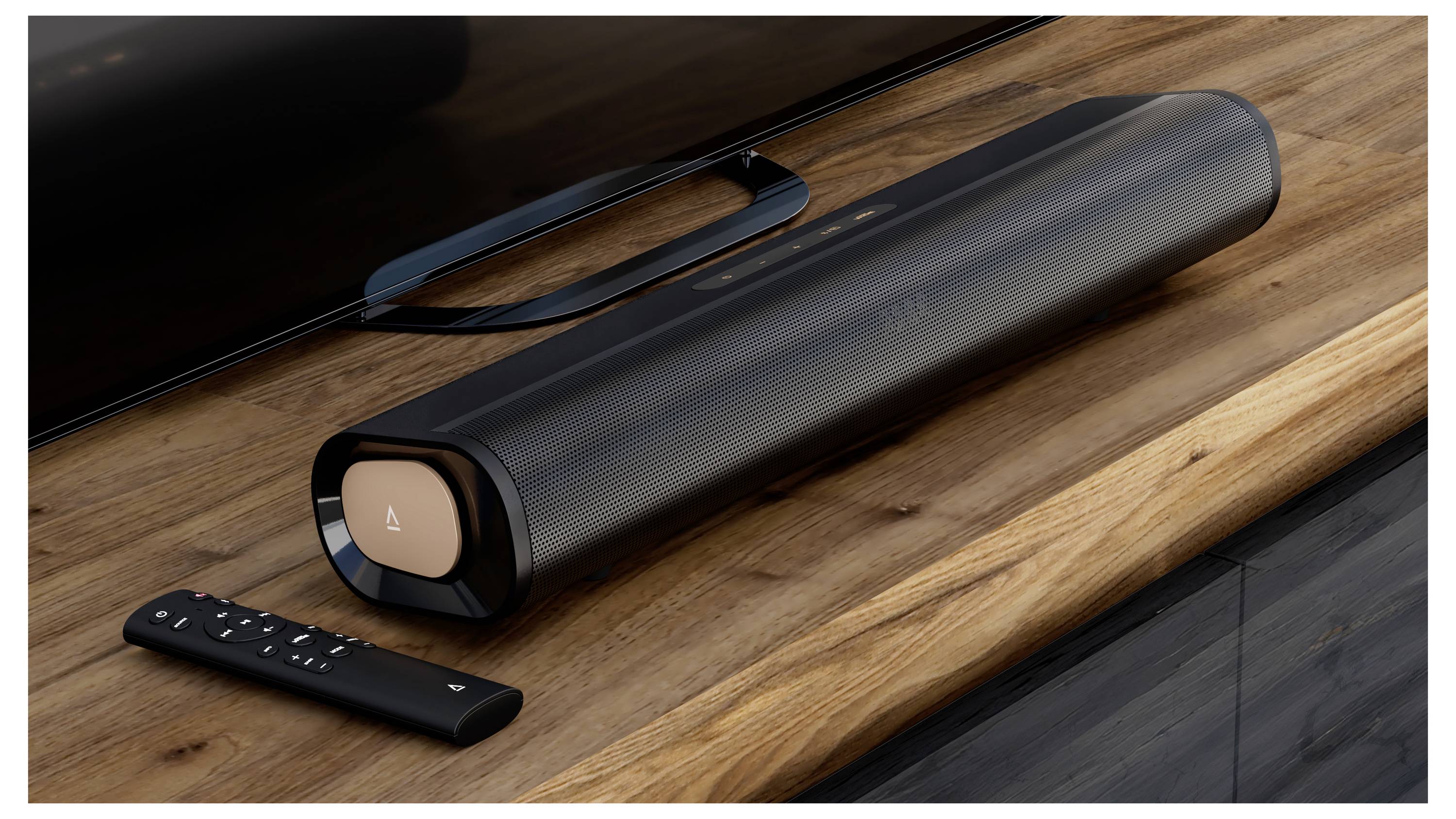 Eleganten črn soundbar leži na leseni TV mizici poleg usklajenega daljinskega upravljalnika. Soundbar ima kovinski zaključni element na koncu.