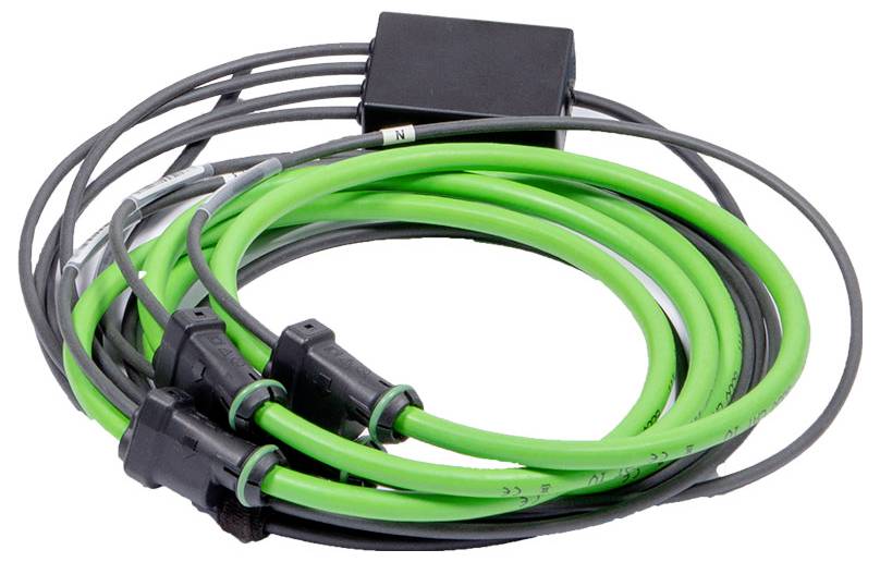 Zaviti zeleni in črni kabli, priključeni na črno škatlo, potencialno namenjeni električni ali podatkovni transmisiji.