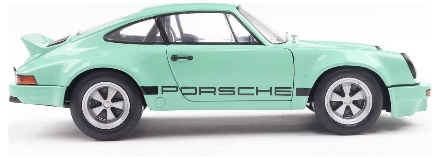 Zeleni športni avto znamke Porsche s napisom 'Porsche' ob strani, z elegantno zasnovo in klasičnim slogom, fotografiran od strani.
