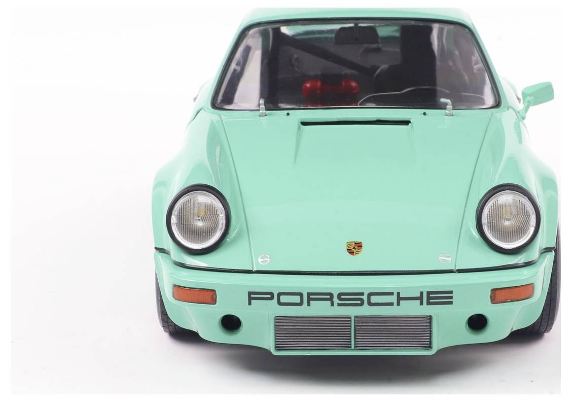Zeleno-mentolski modelček avtomobila znamke Porsche, viden od spredaj.