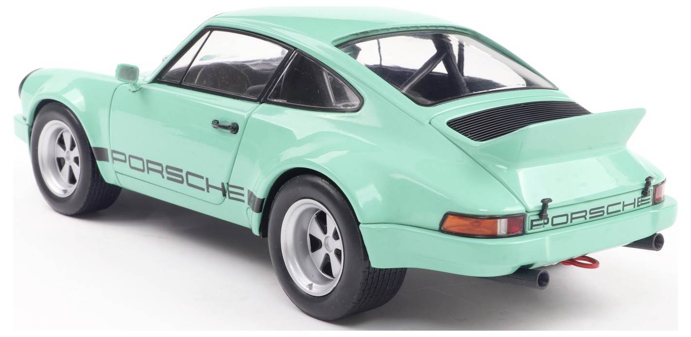 Turkizni vintage športni avto znamke Porsche s štartnimi številkami na strani in zadnji strani, fotografiran pod kotom od zadaj in s strani.