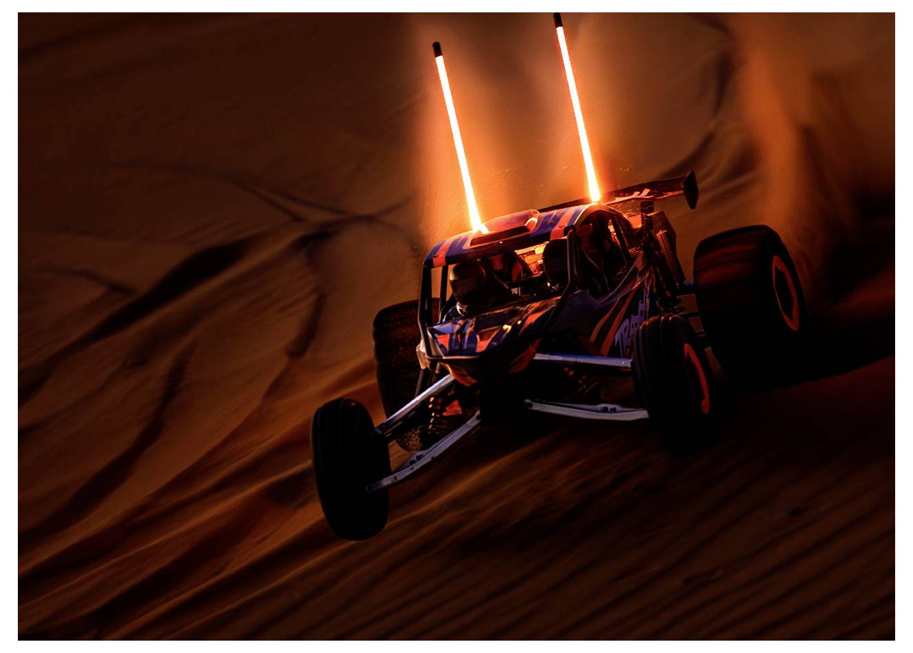 Dune buggy, ki se podi čez peščene sipine ob somraku, pri čemer njegovi žarometi in dve navpični oranžni luči razsvetljujeta prizor.