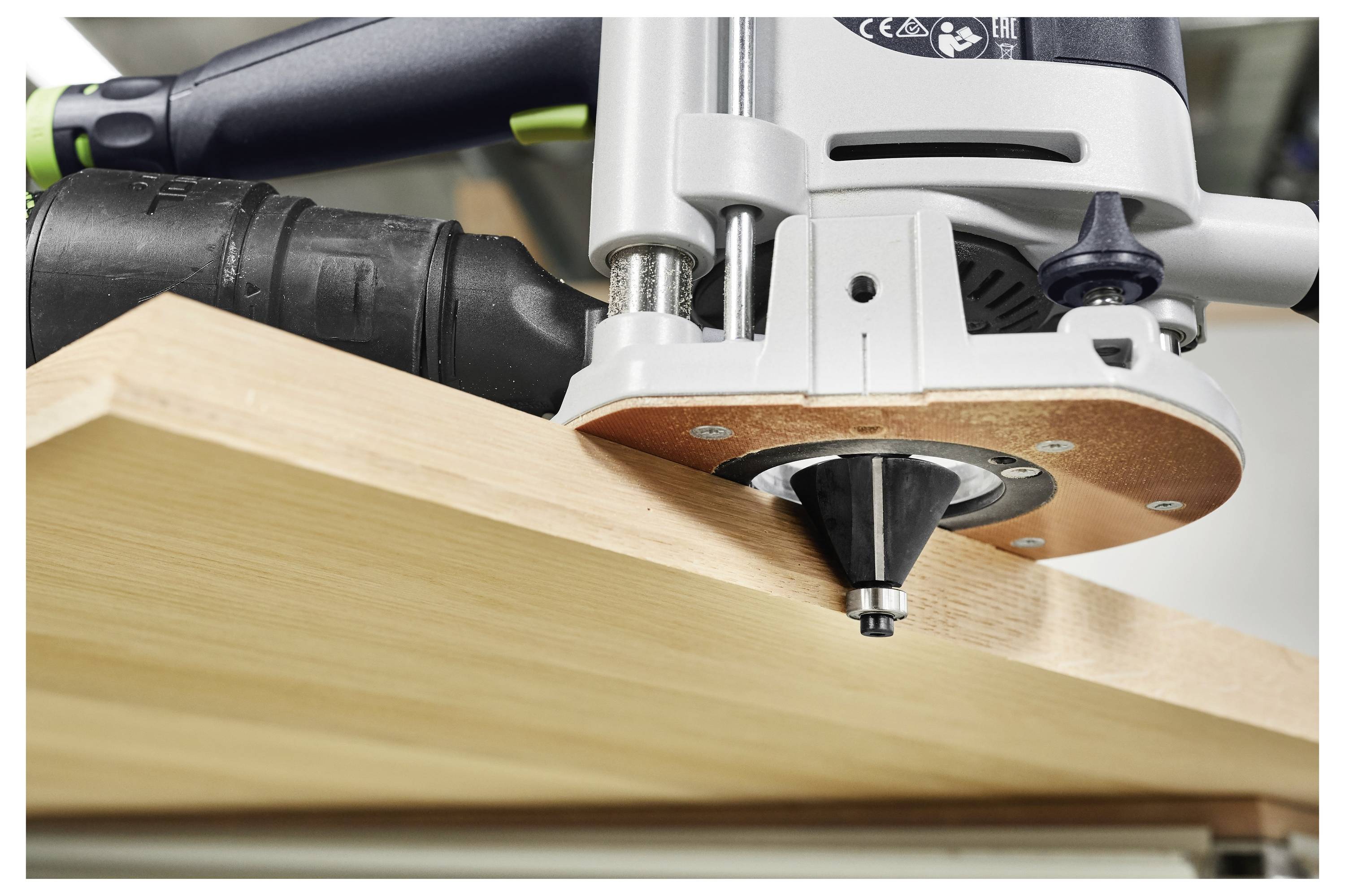 Elektrno orodje s preciznostjo obrezuje rob lesene deske, pri čemer se freza gladko reže v kotu površine.