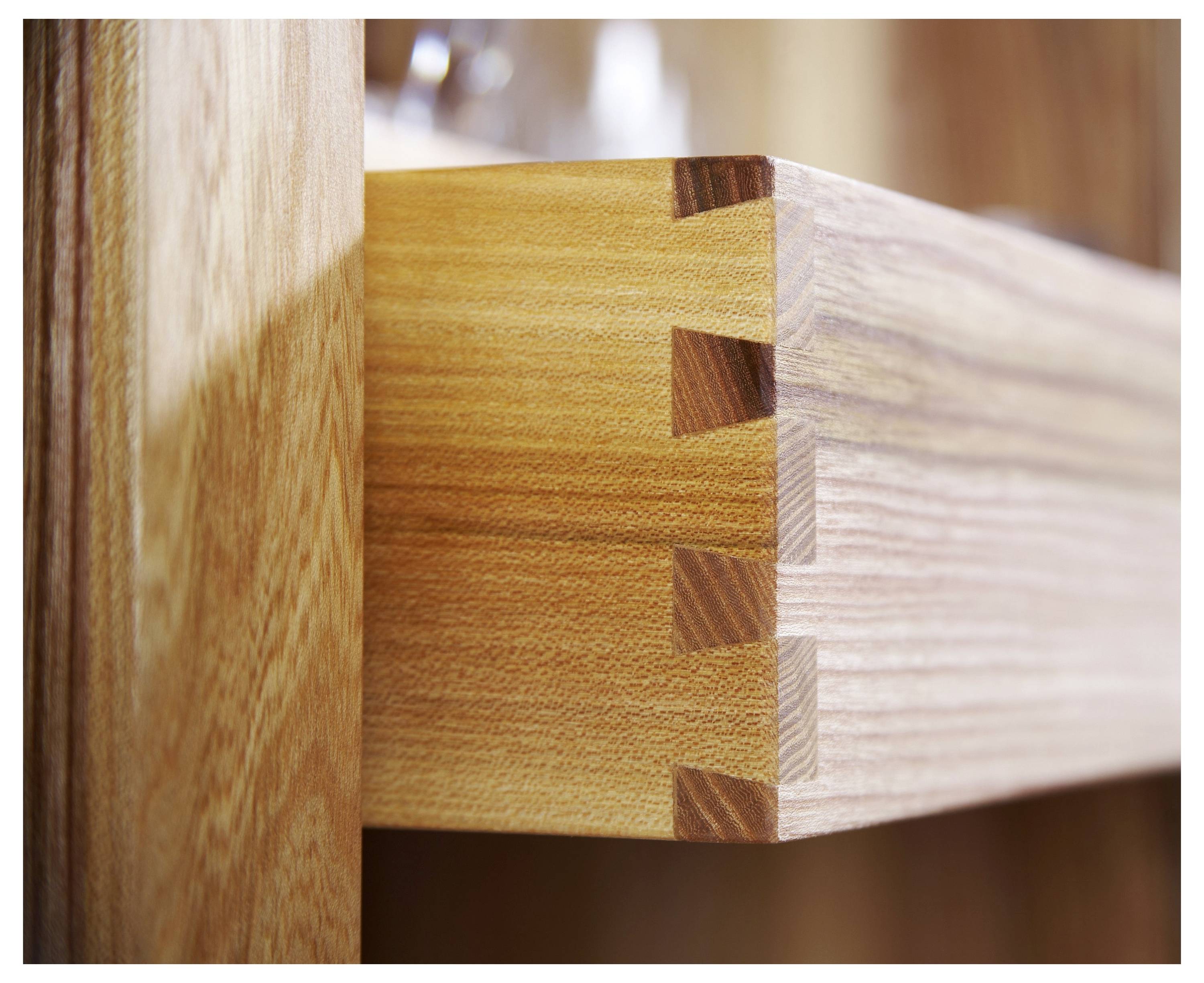 Bližnji pogled na leseno predal, ki prikazuje natančne lastovičaste stike, poudarjajući obrt in teksturo lesa.