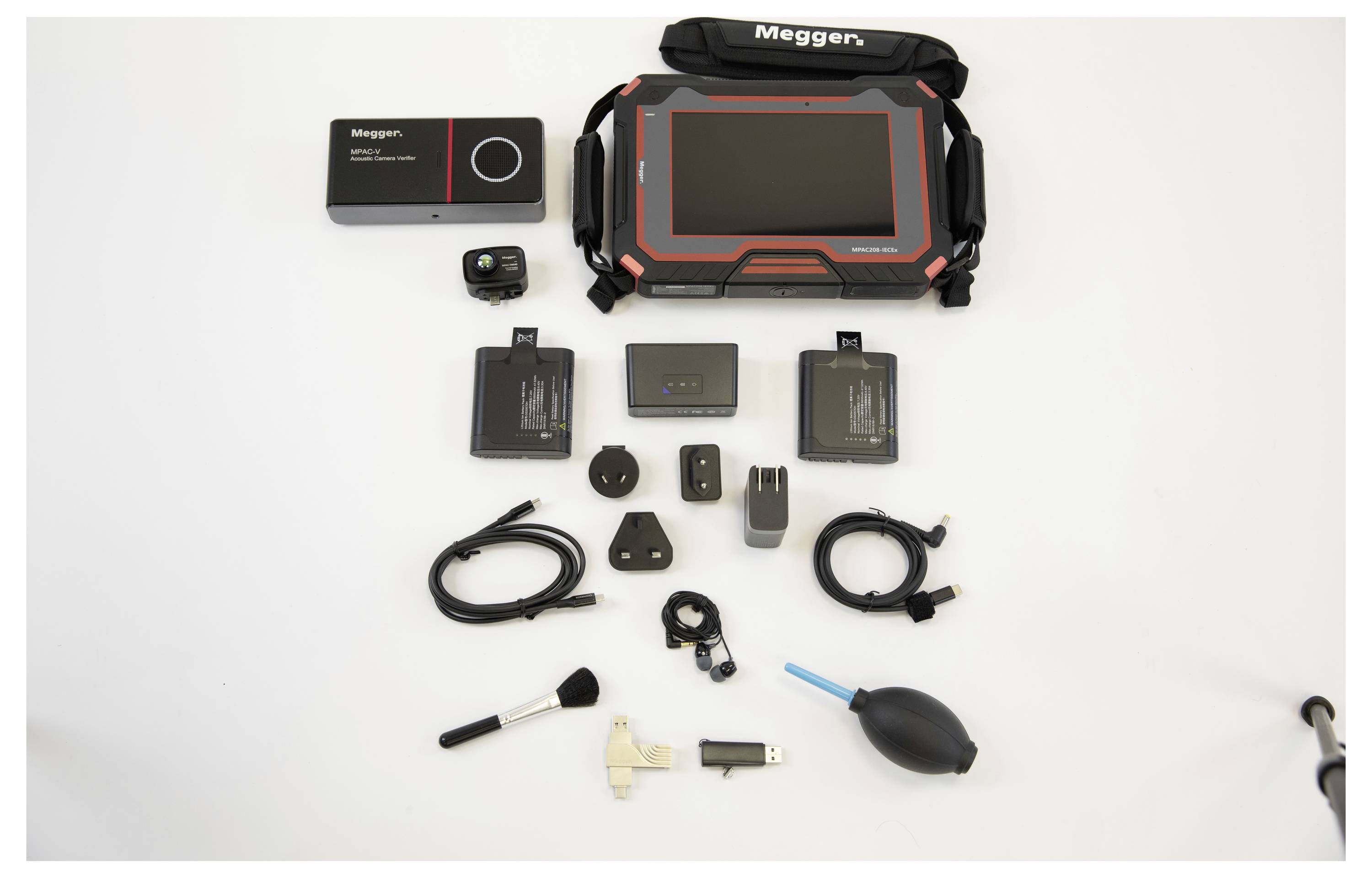 Nabor elektronskih naprav in dodatkov na beli površini, vključno s tablico, polnilnimi kabli, baterijami, adapterji in čistilnimi pripomočki.