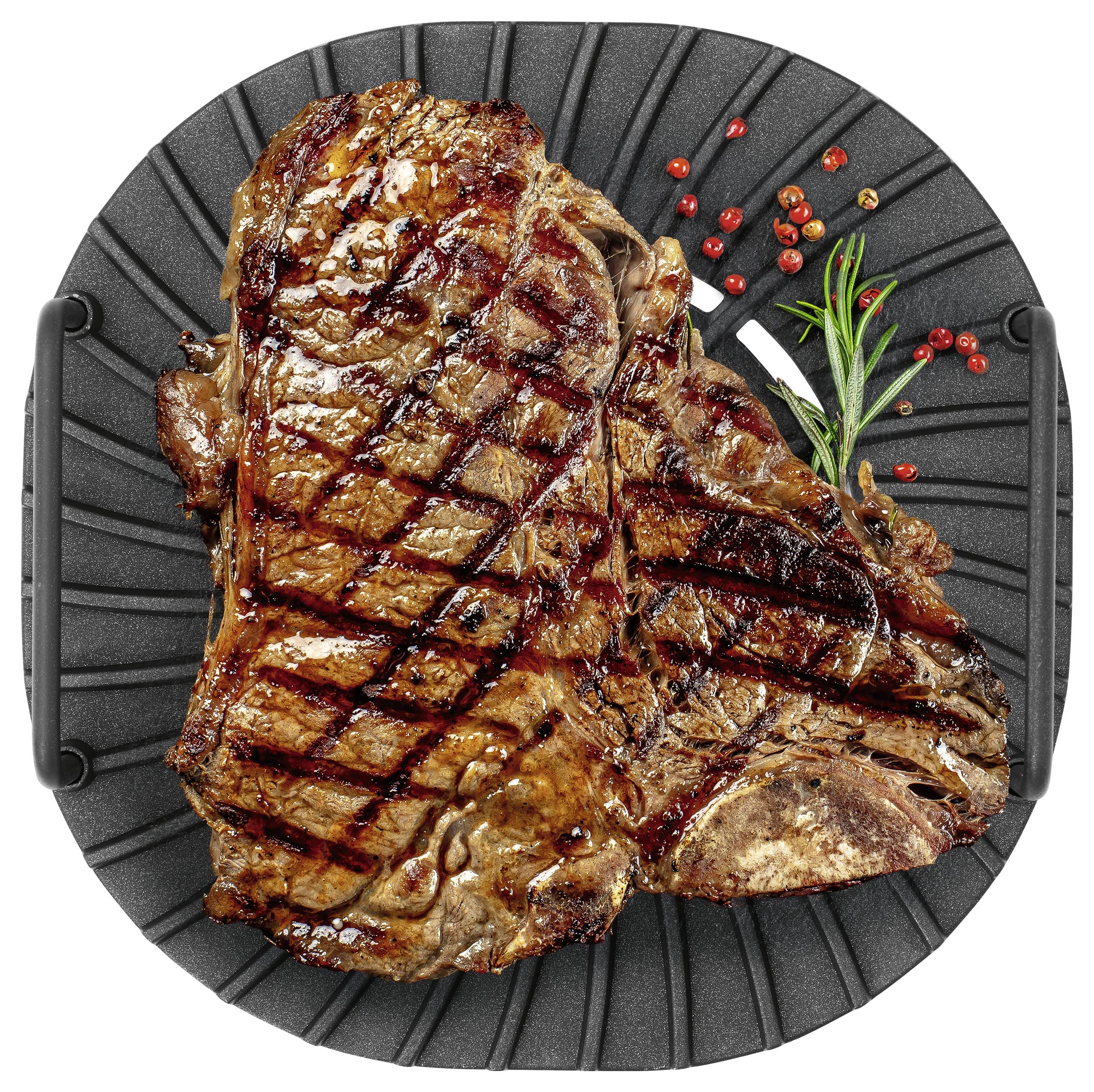 Ocvrt T-bone biftek s križnim vzorcem, okrašen z rozmarinom in piperkovim zrnom, na okrogli črni ponvi.