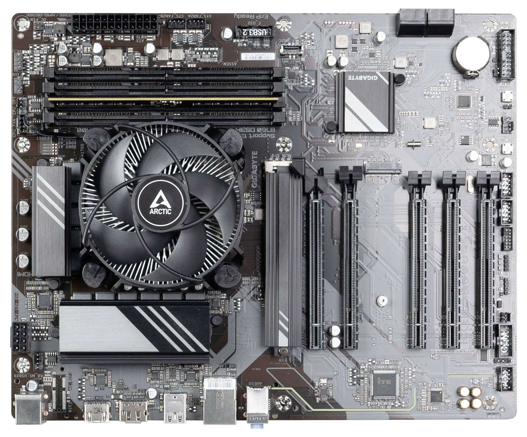 Pogled od zgoraj na matično ploščo računalnika s hladilnikom procesorja, štirimi režami za RAM, več režami PCIe in zadnjimi vhodno-izhodnimi vrati.