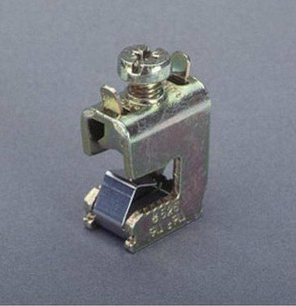 Majhen kovinski električni priključni sponka s vijakom in vzmetnim stikom, prikazan izoliran na sivem ozadju.