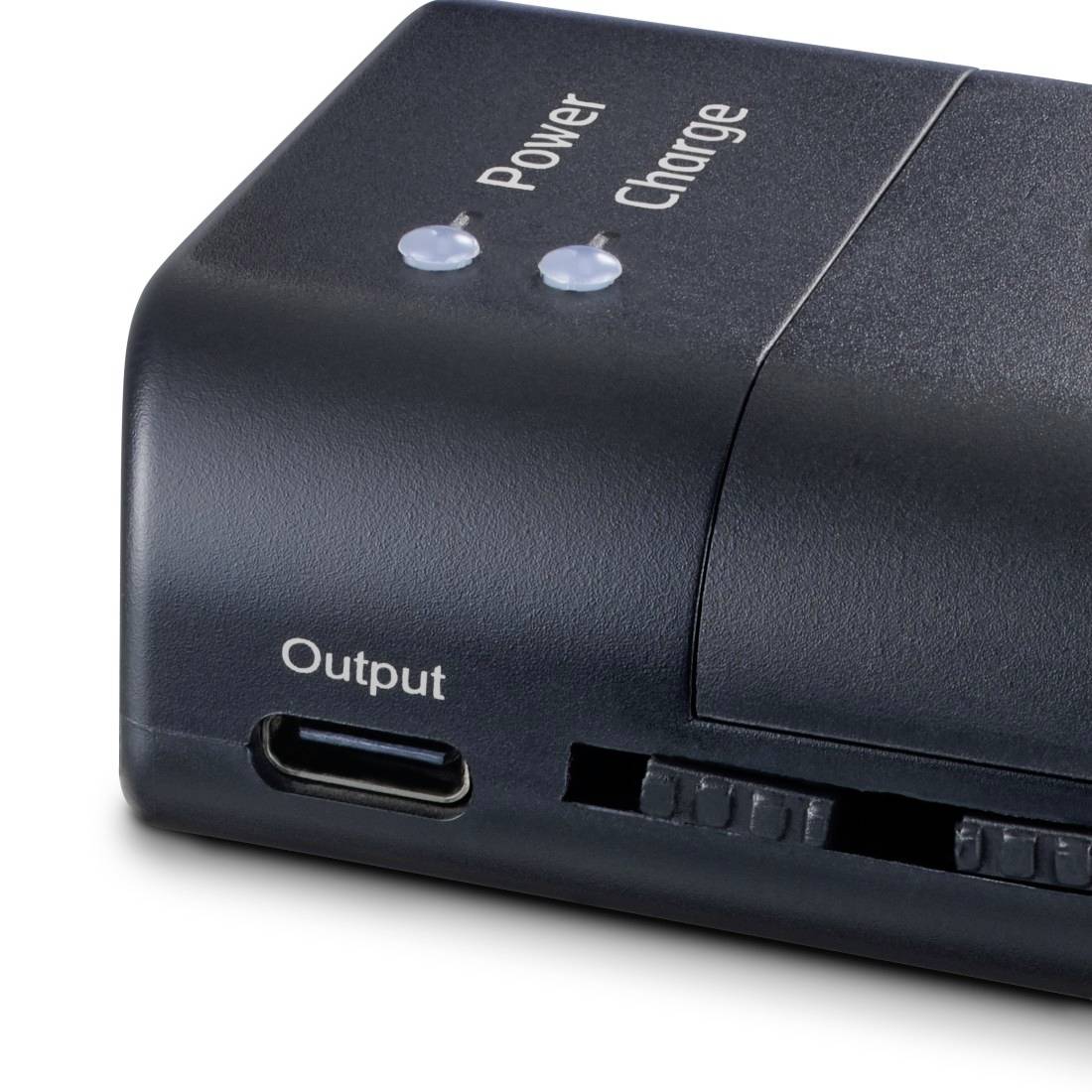 Podrobni pogled na črno power banko s svetlobnimi indikatorji za napajanje in polnjenje, izhodno vrato USB-C in stranskim drsnim stikalom.