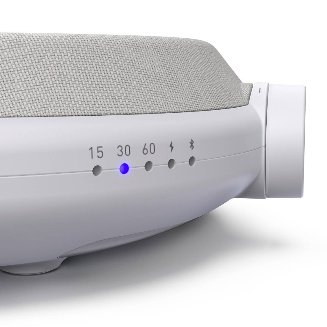 Detaljni pogled na belo napravo s tkanino na vrhu in kontrolnimi lučkami označenimi 15, 30, 60, power in Bluetooth; lučka 30 sveti modro.