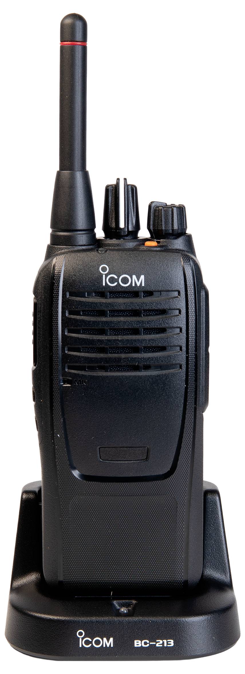 Črna ročna dvosmerna radijska postaja Icom, ki stoji v polnilni postaji na belem ozadju.