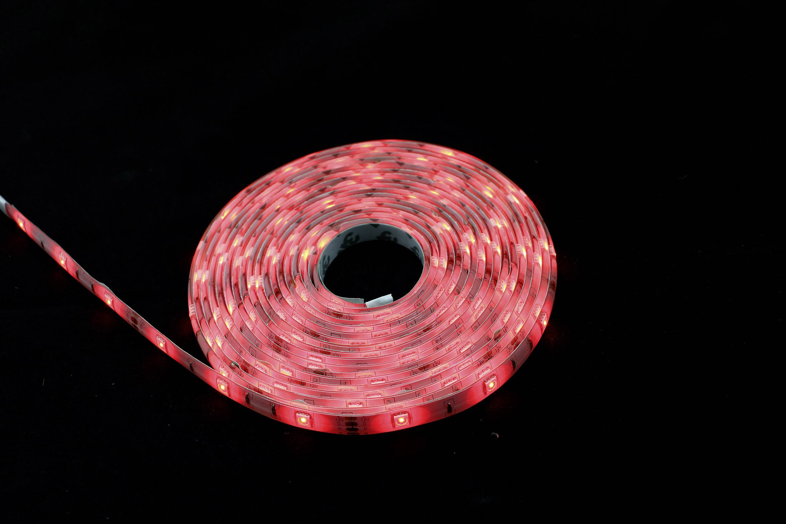 Zvita LED-svetlobna veriga sveti rdeče na temni podlagi.