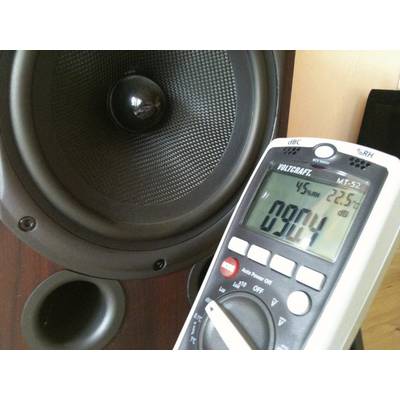Zvočnik in voltmeter, ki prikazuje meritev hrupa 90,4 deciblov. Voltmeter meri raven zvočnega tlaka.