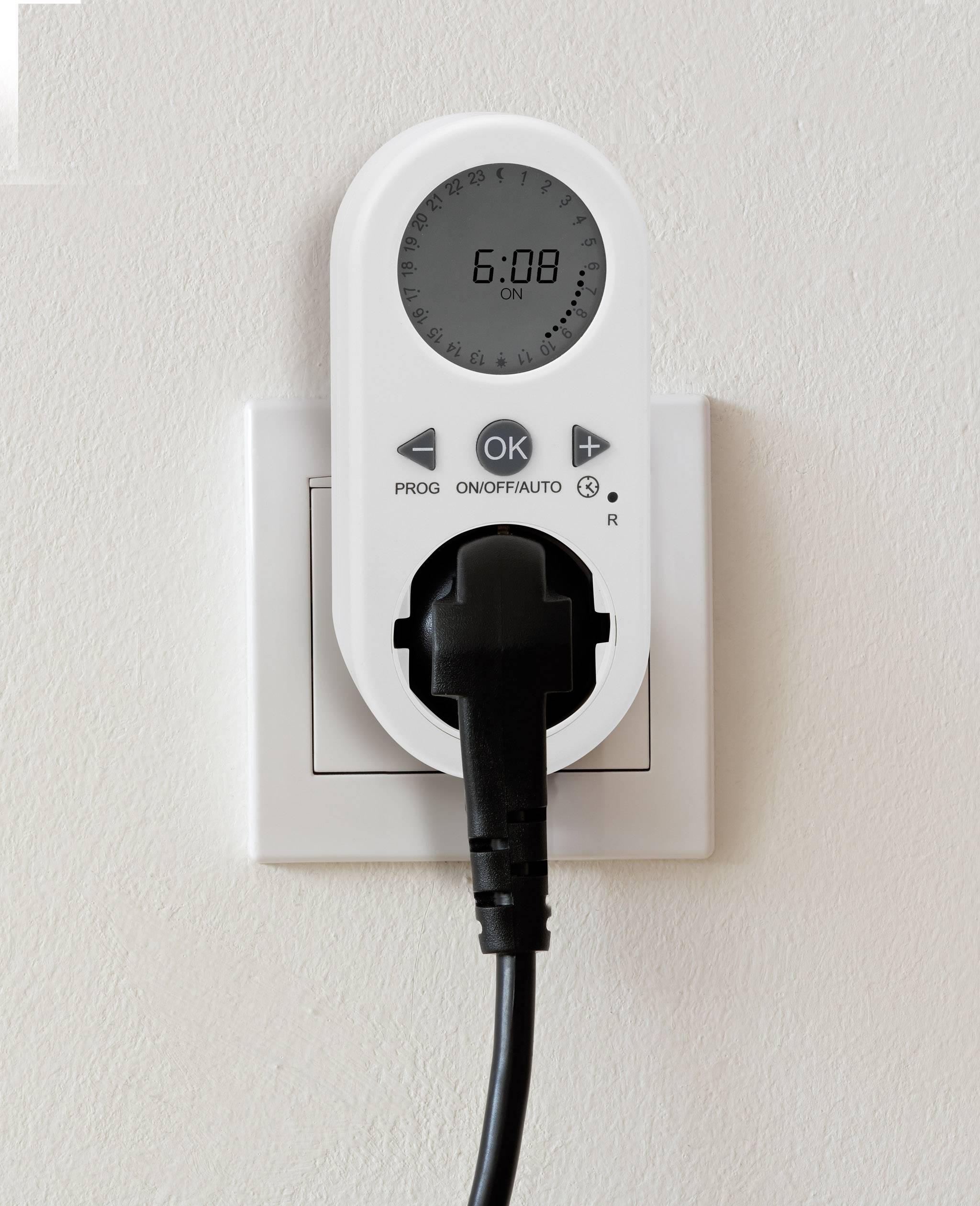 Digitalni merilnik časa v vtičnici, prikazuje čas 6:08. Vanj je vtaknjen električni kabel. Funkcije: Prog, OK, On/Off/Auto.
