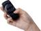 Ena roka drži črno daljinsko upravljanje z gumbi za uravnavanje glasnosti in stikalom za vklop/izklop.