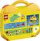 Rumeni LEGO kovček z priloženimi začetniškimi gradbenimi idejami. Prikazuje majhne, preproste konstrukte kot so hiša, raca in raketa. Idealen za prenosljivo LEGO zabavo.