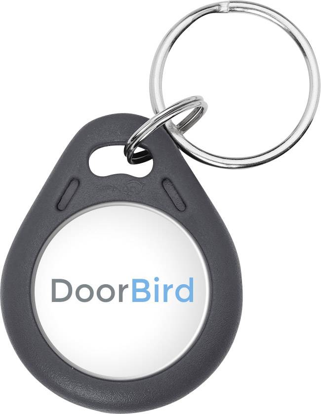 Obesek za ključe z okroglim belim središčem, na katerem piše 'DoorBird' modro in sivo obarvano.