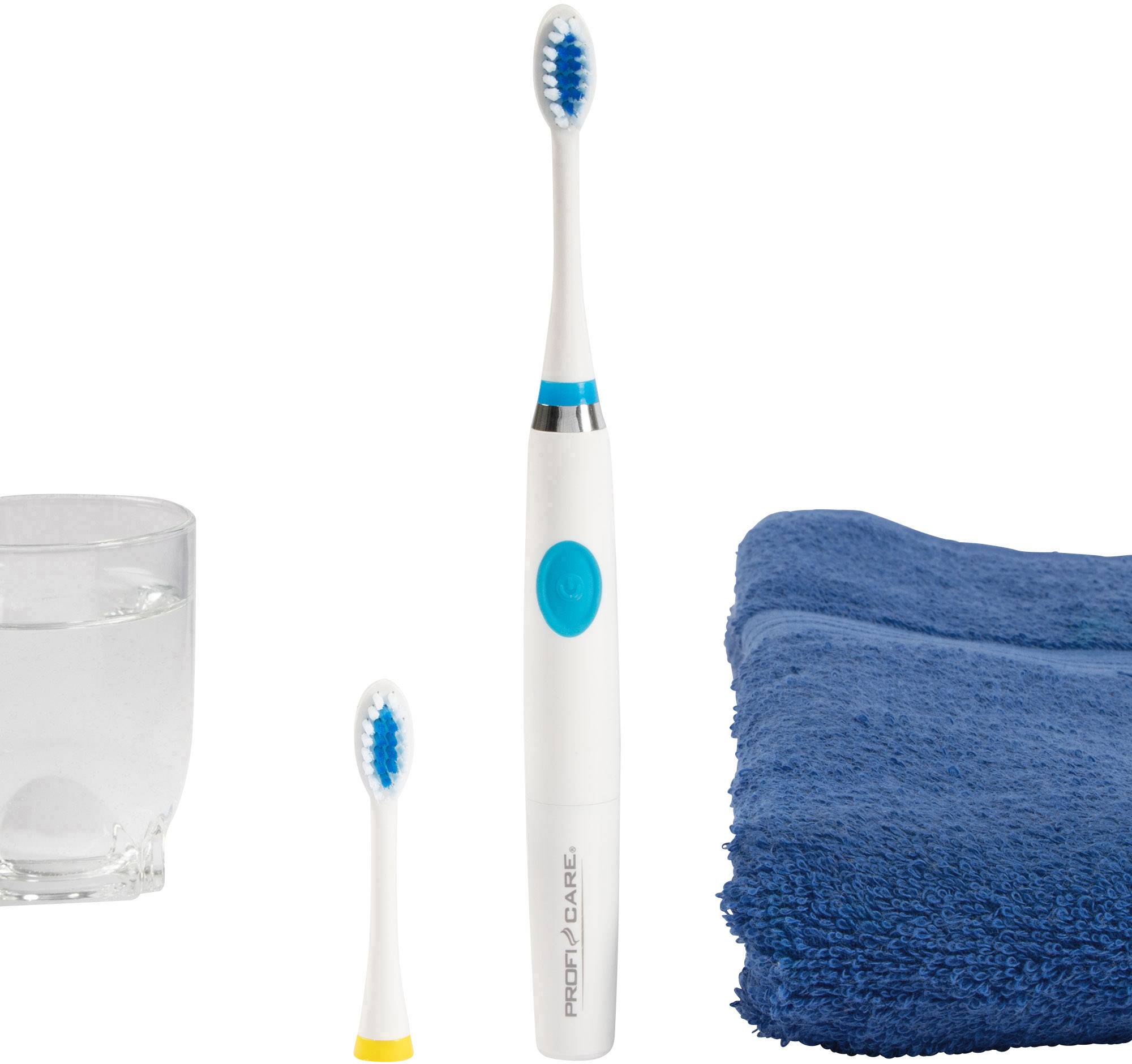 Električna zobna ščetka zraven nadomestne glave ščetke, steklenega kozarca z vodo in zloženega modrega brisača na beli podlagi.