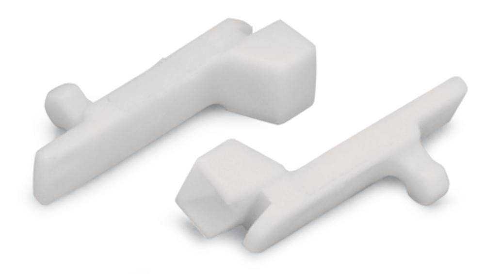 Dva bela plastična dela z geometrijskimi oblikami in štrlečimi kljukicami, ležeča na beli podlagi.