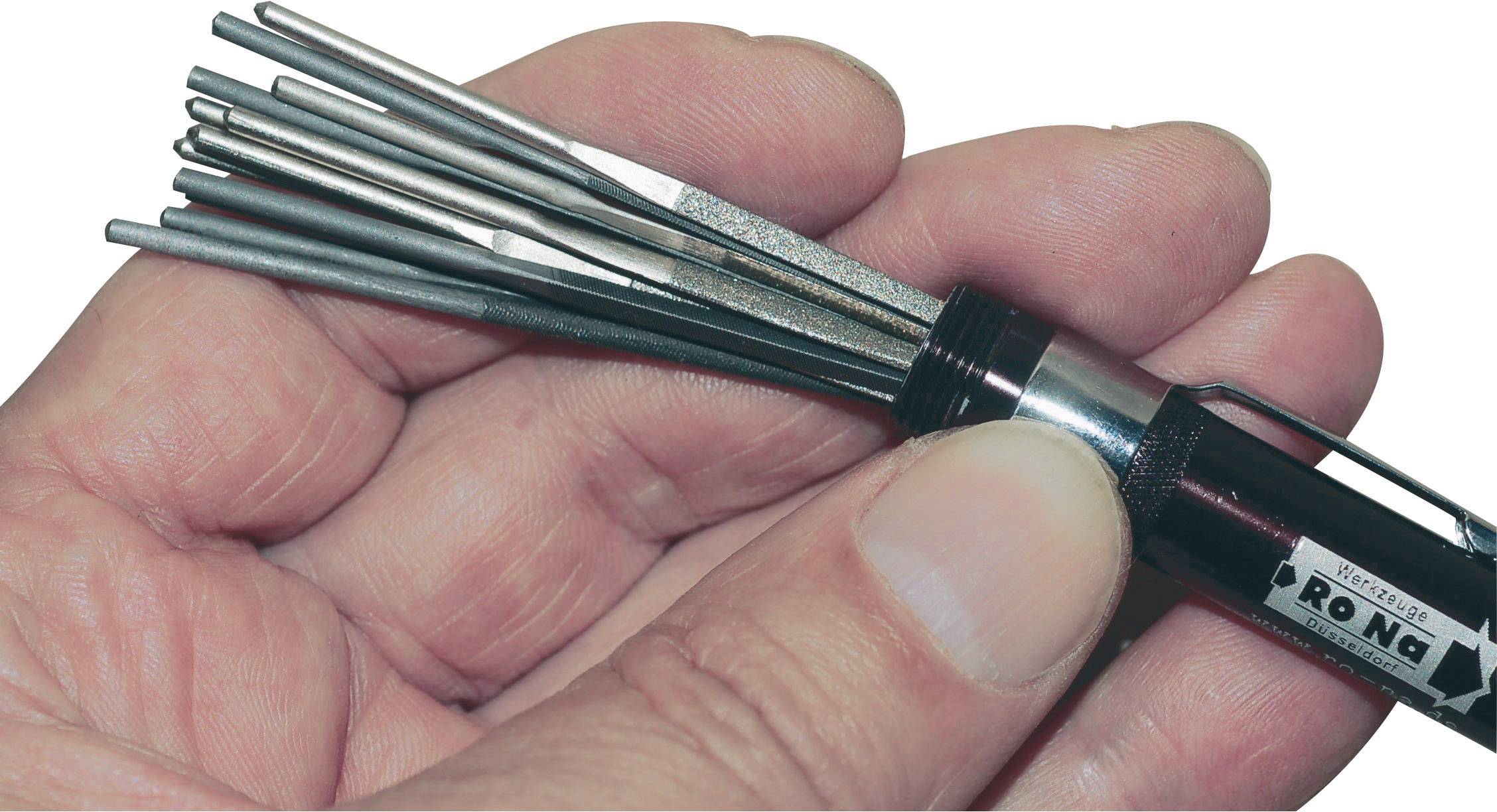 Roka drži pahljačast set datovsnih pilov. Komplet sestoji iz več finih kovinskih pilov, ki so združeni v enem ročaju.