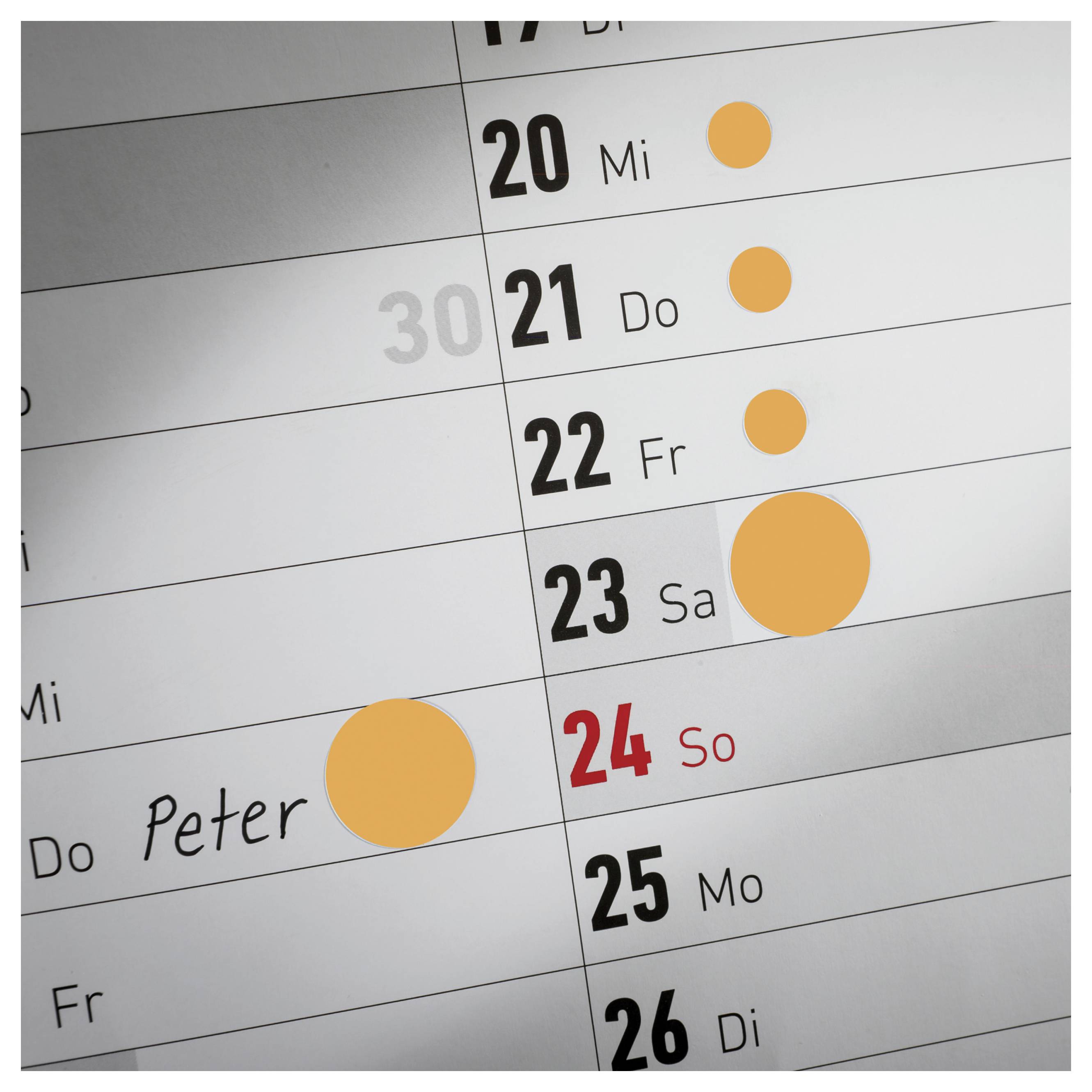 Kalendervy med markerade möten på flera dagar; en post 'Peter' den 23:e och färgade cirklar som händelser bredvid 20–24.