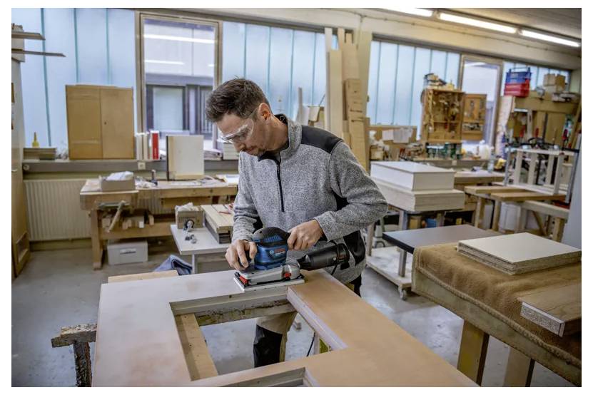 Bosch elkedjesåg med monterade sågtänder visad på vit bakgrund.