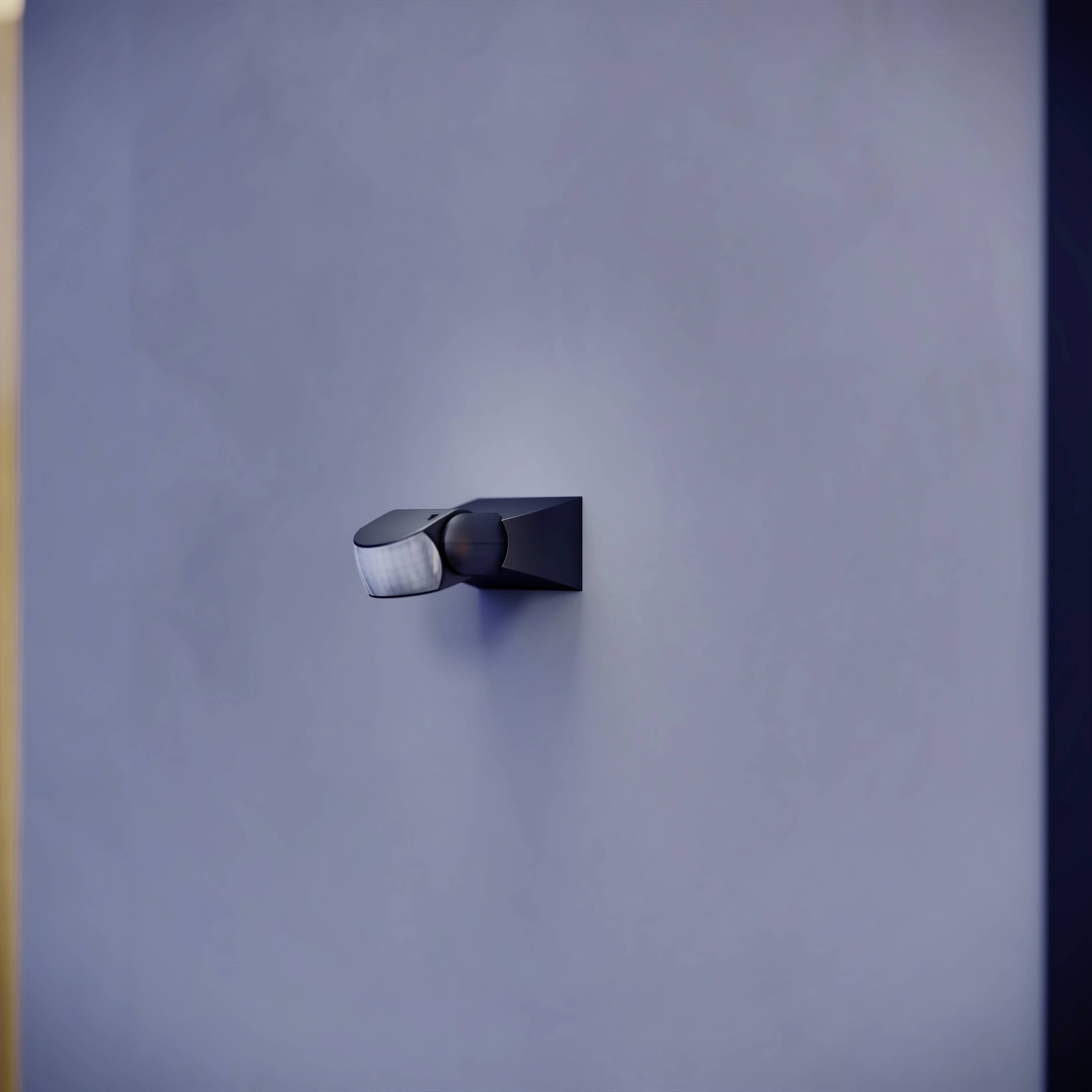 En modern svart vägglampa lyser på en grå vägg och skapar ett mjukt, jämnt ljus i rummet.