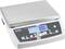 En digital våg med en display som visar '0.00'. Den har flera funktionsknappar och är tillverkad av metall och plast.