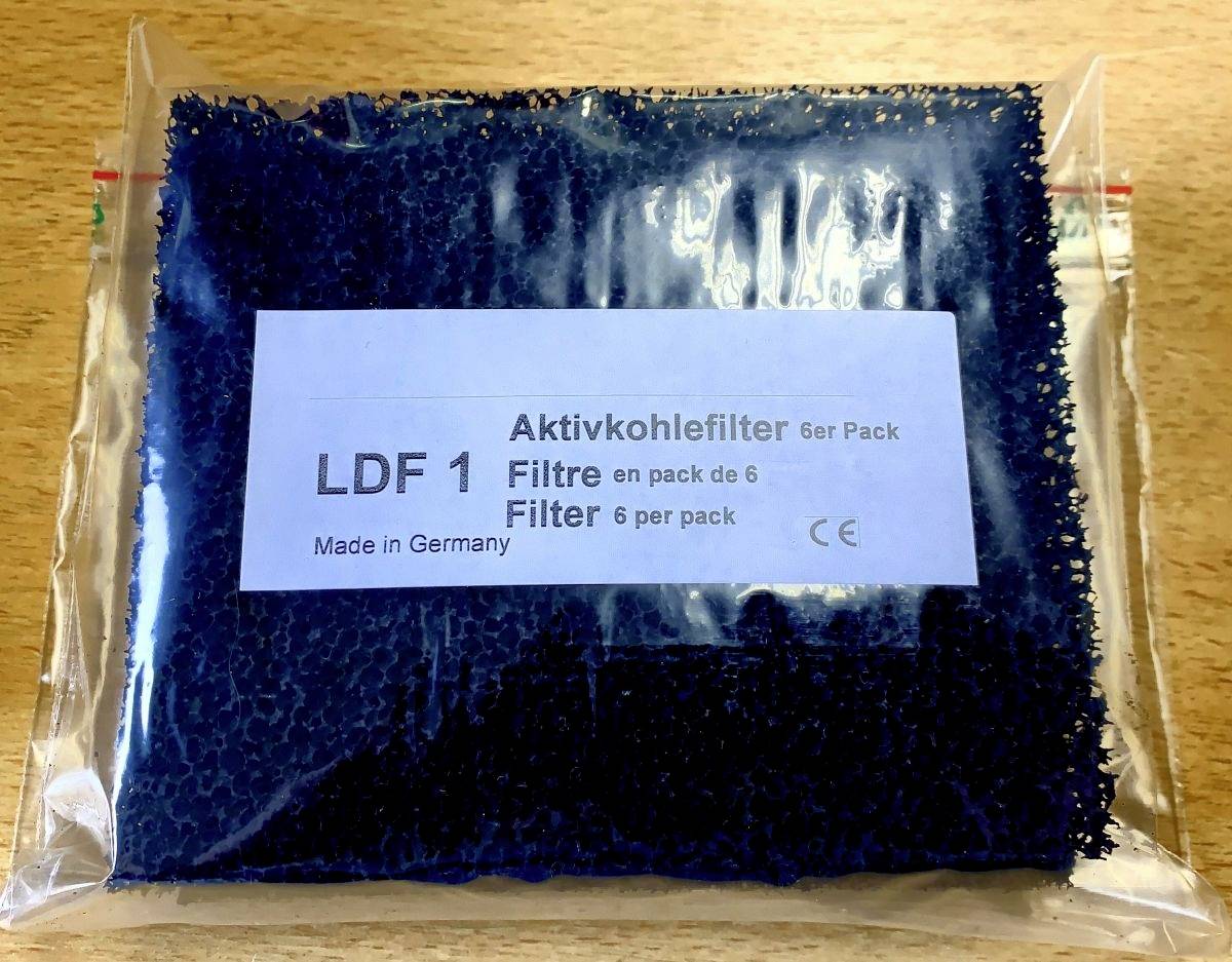 "Aktivt kolfilter 6-pack" står på etiketten på en förpackning med blå filter, tillverkade i Tyskland.
