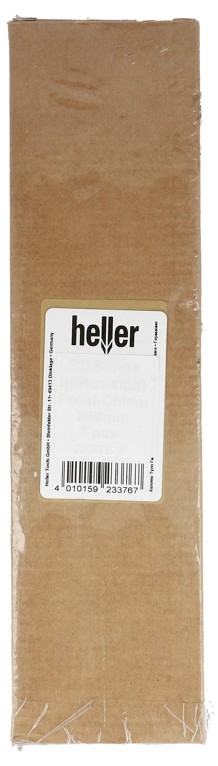 En person borrar ett hål i en mörk panel med en grön trådlös borrmaskin i en verkstad eller förrådsområde.