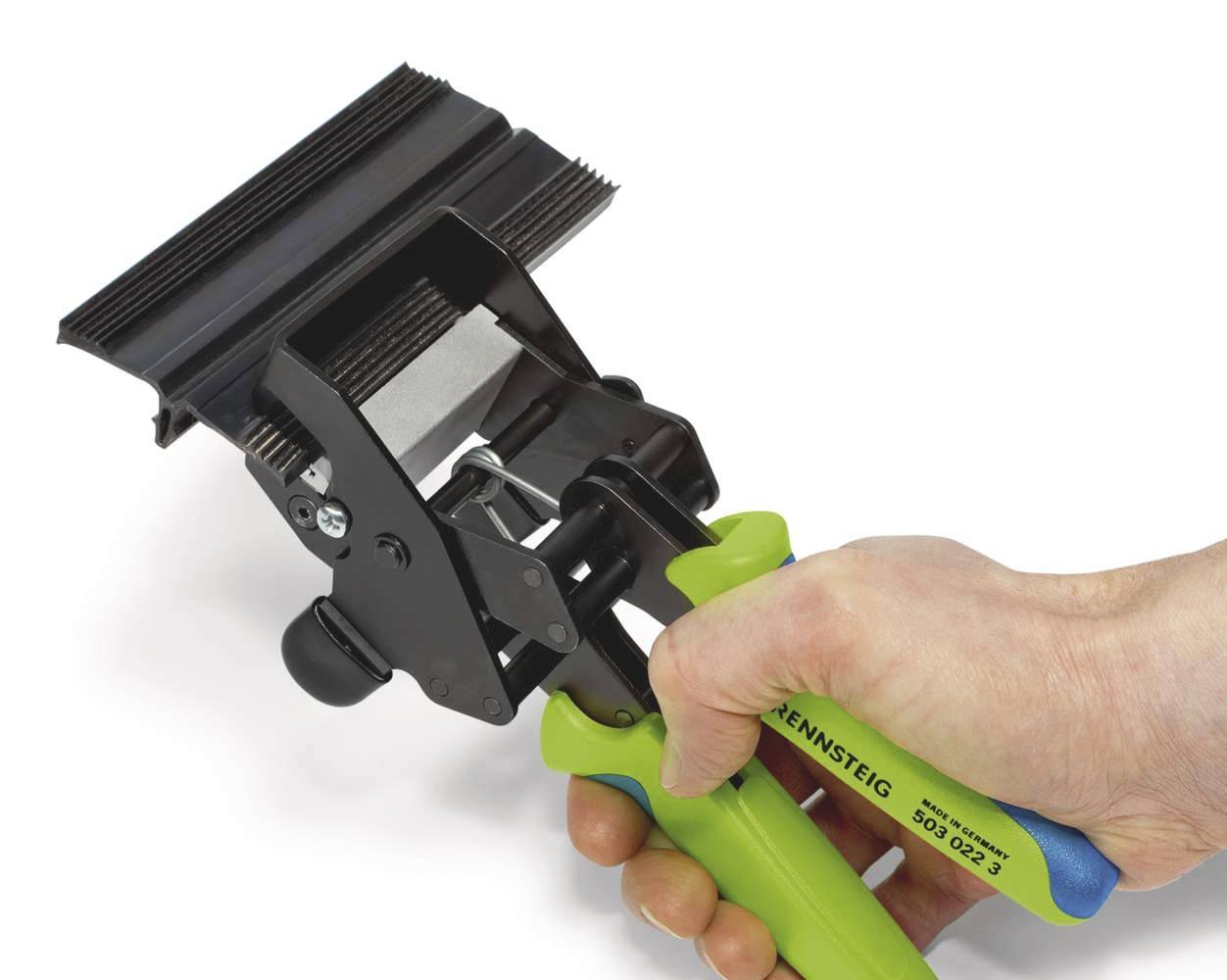 En hand håller ett grönt och svart crimping-verktyg som bearbetar kabeltrådar med ett tandförsett huvud.