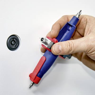 En hand håller en blå momentnyckel med rött handtag, som används för att låsa en vit dörr. Ett lås är synligt.