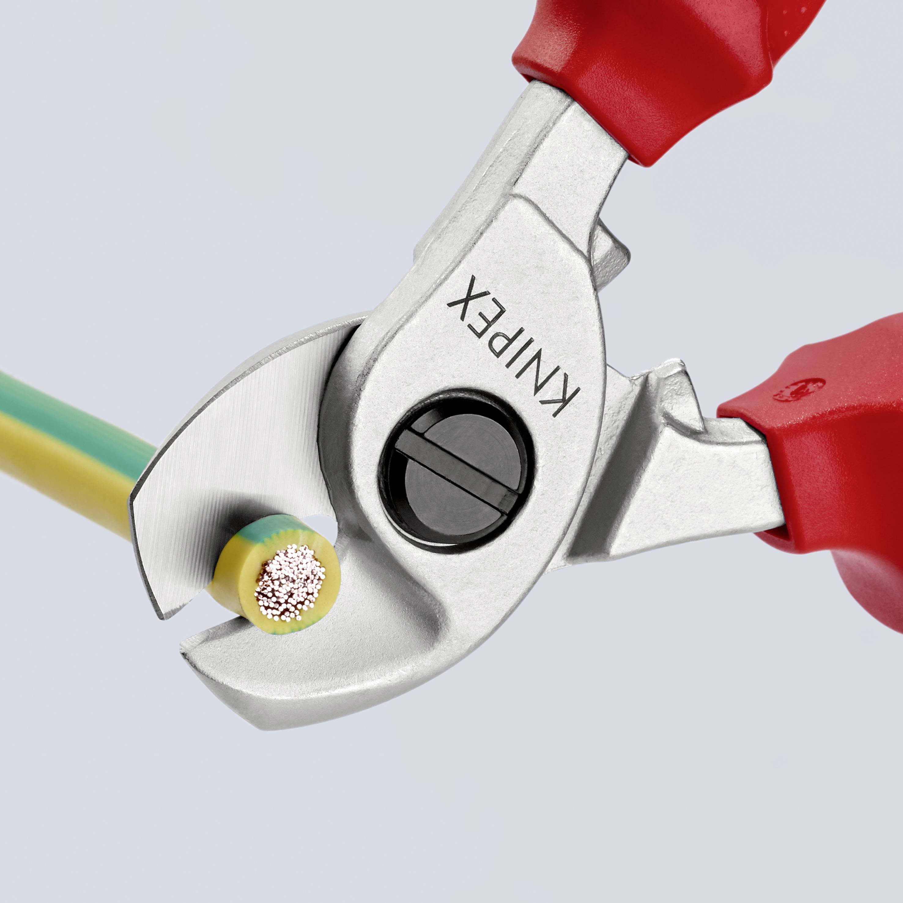 En tång klipper av en kabel med röd och grön tråd. Tången är silverfärgad med röda handtag, och på den står det 'KNIPEX'.