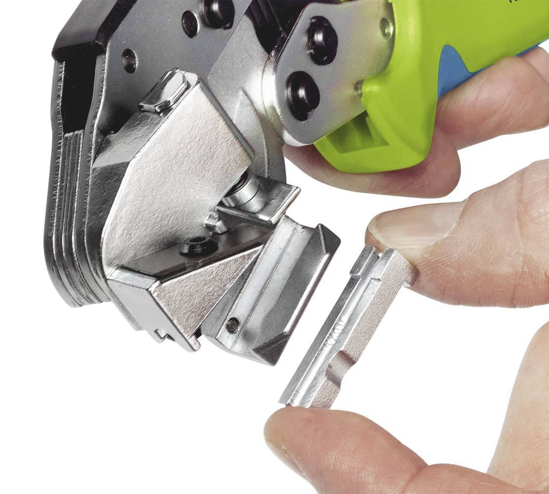 En hand håller en avtagbar metalldetalj framför ett verktyg med ett grönt handtag, som används för att skära eller klämma.
