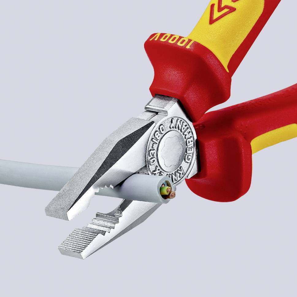 En avbitartång med isolerade handtag klipper av en elektrisk kabel och visar på säkerhet vid arbete med elektricitet.