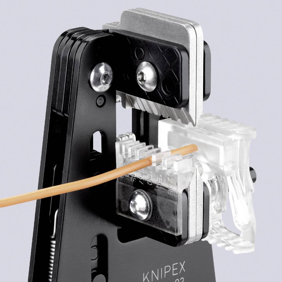 Ett verktyg klipper av en orangefärgad kabel som leder in i en transparent förbindningskläm.