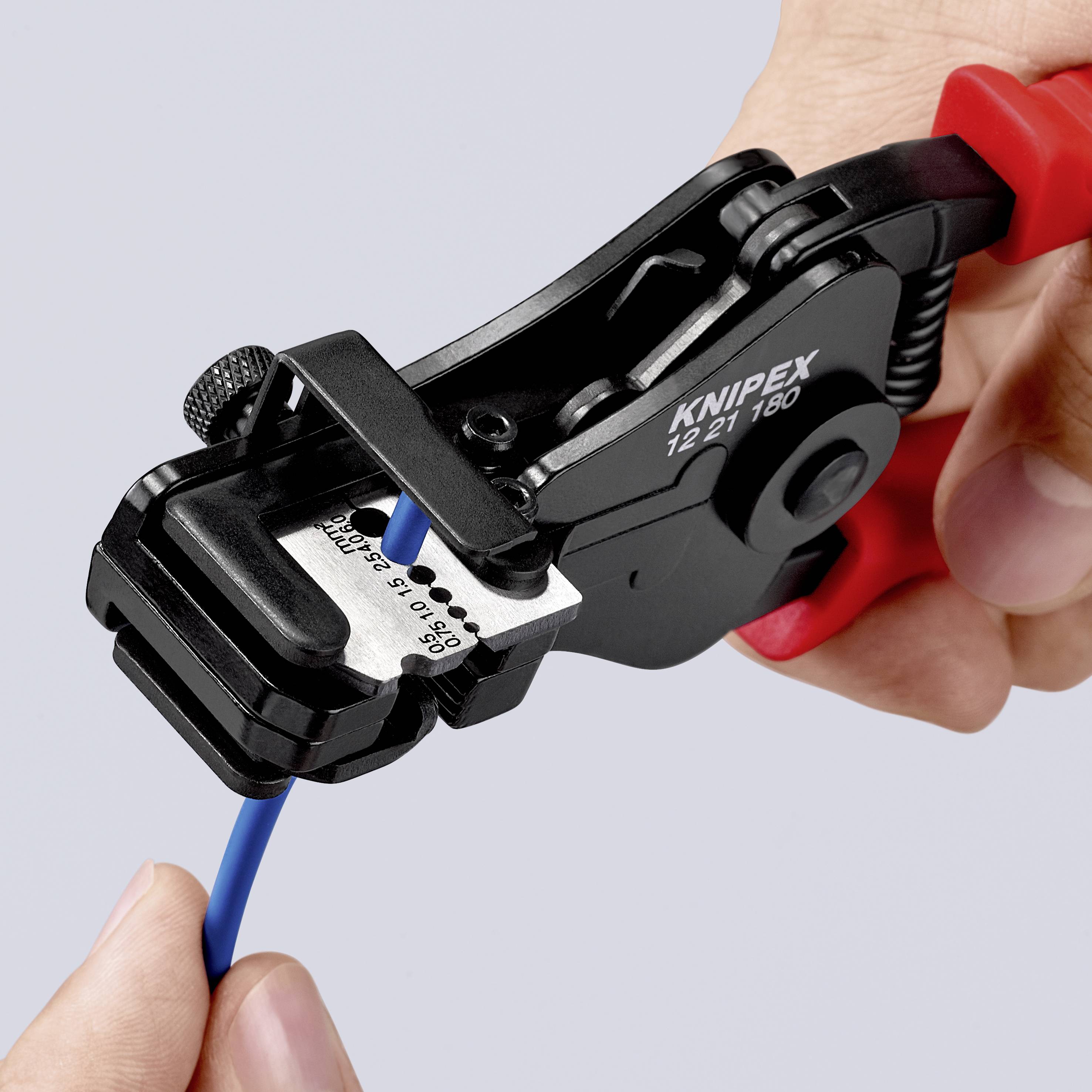 En hand håller en röd och svart avisoleringstång som aviso­lerar en blå kabel. På tången står det 'KNIPEX 12 21 180'.